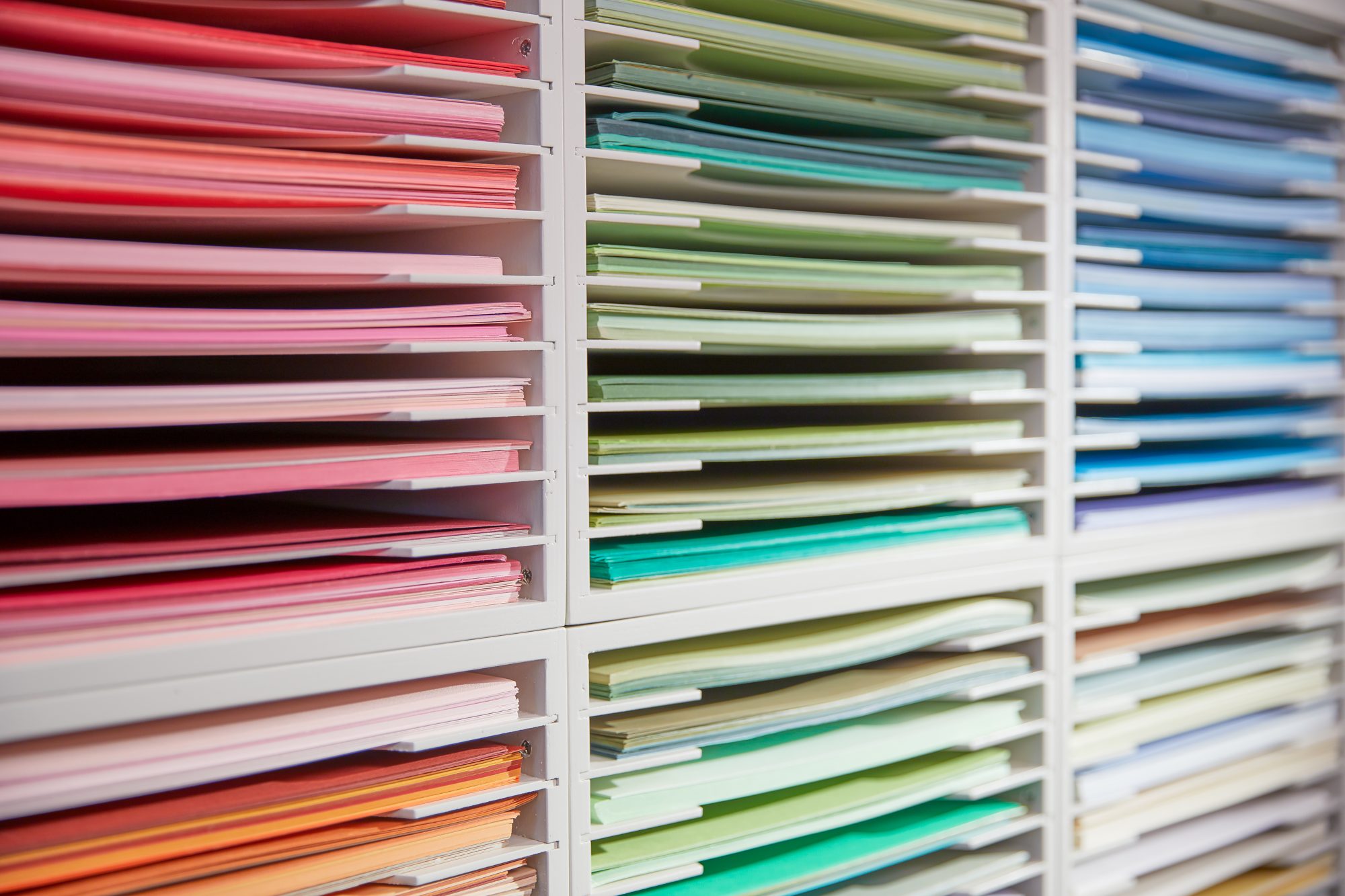 Rows of colorful cardstock in white Stamp-n-Storage paper holders